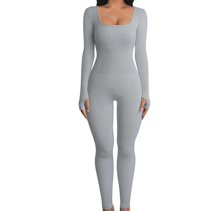 Woman wearing seamless long-sleeve yoga jumpsuit in stylish athleisure pose